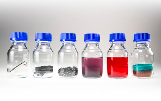Battery material samples in small bottles organized in a row