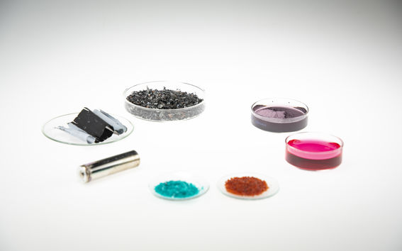 Battery metal and material samples on glass dishes organized in a circle