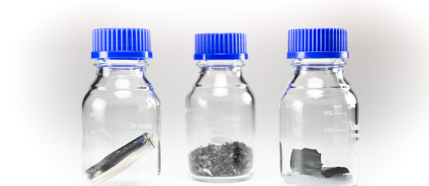 Photo of scrap battery materials in sample bottles