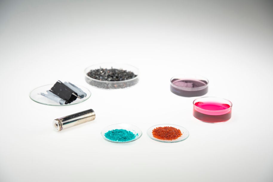 Battery metal and material samples on glass dishes organized in a circle